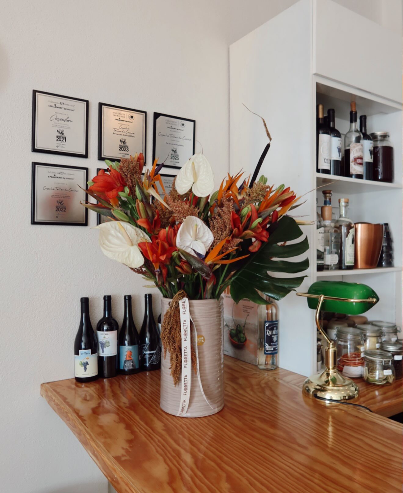 Interior de Cosecha con flores tropicales, barra de madera y reconocimientos enmarcados